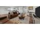 Inviting living room with warm leather sofas, a striking coffee table, and a seamless transition to the modern kitchen at 45 Florentine Ct, Angier, NC 27501