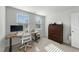 Bright home office space with a wooden desk and a rustic wood dresser, bathed in natural light from two large windows at 45 Florentine Ct, Angier, NC 27501