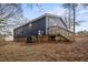 Home exterior featuring navy siding, brick foundation, deck with wooden staircase, and well maintained yard at 453 Deer Vw, Sanford, NC 27332