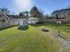 Expansive backyard featuring lush green lawn, shed, and fire pit for outdoor entertaining and relaxation at 4709 Wyndchase Ct, Fuquay Varina, NC 27526