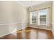 Well-lit dining room with wood floors, contemporary chandelier, and large windows at 4709 Wyndchase Ct, Fuquay Varina, NC 27526