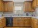 Close-up of the kitchen with wooden cabinetry, stainless steel sink, and black dishwasher at 4709 Wyndchase Ct, Fuquay Varina, NC 27526