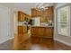 Open eat-in kitchen with wood cabinets, modern lighting, stainless steel appliances, and stone countertops at 4709 Wyndchase Ct, Fuquay Varina, NC 27526
