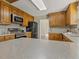 Bright kitchen featuring wood cabinets, stainless steel appliances, and stone countertops at 4709 Wyndchase Ct, Fuquay Varina, NC 27526