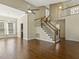 Open-concept living room with hardwood floors, staircase, high ceiling, and a ceiling fan at 4709 Wyndchase Ct, Fuquay Varina, NC 27526