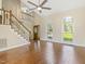Spacious living room featuring hardwood floors, staircase, and large windows at 4709 Wyndchase Ct, Fuquay Varina, NC 27526