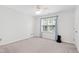 Well-lit bedroom featuring neutral carpeting and a ceiling fan at 5117 Singing Wind Dr, Raleigh, NC 27612