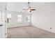 Spacious bedroom with multiple windows, neutral carpet, and ceiling fan at 5117 Singing Wind Dr, Raleigh, NC 27612