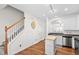 Bright kitchen with a mobile island, stainless appliances, and stair access at 5117 Singing Wind Dr, Raleigh, NC 27612