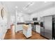 Bright kitchen with white cabinets, stainless steel appliances, and hardwood floors at 5117 Singing Wind Dr, Raleigh, NC 27612