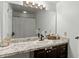 Bathroom with granite countertop, dark wood cabinets, and framed mirror at 600 Audubon Lake Dr # 5A32, Durham, NC 27713