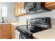 Bright kitchen features black appliances, wooden cabinets, and laminate countertops at 600 Audubon Lake Dr # 5A32, Durham, NC 27713