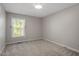 Neutral bedroom featuring carpeted floors and a bright window with wooded views at 6025 Spring Valley Dr, Raleigh, NC 27616