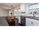 Kitchen area with stainless steel dishwasher, white cabinets, and adjacent dining area at 609 S Allen Rd, Wake Forest, NC 27587