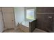 Modern bathroom with gray tile, a large tub, and separate shower at 622 Ravensworth Dr, Garner, NC 27529