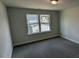 This bedroom features neutral walls, carpet flooring, and a window overlooking the neighborhood at 622 Ravensworth Dr, Garner, NC 27529