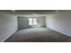 This living room features neutral walls, carpet flooring, and a window for natural light at 622 Ravensworth Dr, Garner, NC 27529