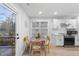 Bright dining area with wood floors, white cabinets, stainless steel appliances, and a view of the outdoor deck at 628 Bragg St, Raleigh, NC 27610