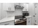 Stylish kitchen showcasing white cabinets, stainless steel appliances, white subway tile backsplash, and modern countertops at 628 Bragg St, Raleigh, NC 27610