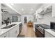 Well-lit open kitchen and dining area featuring white cabinets, stainless appliances, and a view to the back deck at 628 Bragg St, Raleigh, NC 27610