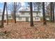 View of the back of the house with a lawn covered in leaves and a double door at 6309 Cape Charles Dr, Raleigh, NC 27617