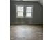Well-lit bedroom featuring two windows and new flooring at 728 East Ave, Henderson, NC 27536