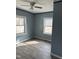 Bedroom featuring two windows, new flooring and ceiling fan at 728 East Ave, Henderson, NC 27536