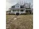 Quaint home featuring a covered porch and carport, set on a lot with mature trees at 728 East Ave, Henderson, NC 27536