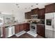 Open-concept kitchen featuring stainless steel appliances and dark wood cabinetry at 7832 Allscott Way, Raleigh, NC 27612