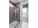 Contemporary bathroom showcasing a glass-enclosed shower with herringbone tile and marble floors at 810 Hyperion Aly, Wake Forest, NC 27587