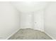 A simplistic bedroom featuring neutral carpet, with two white doors and light grey walls at 94 E Grove Point Dr, Clayton, NC 27527