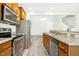 The kitchen features stainless steel appliances and leads to the living room and staircase at 94 E Grove Point Dr, Clayton, NC 27527