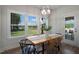 Dining room with a wood table, modern chandelier, large windows, and access to backyard at 35 Merle Dr, Wendell, NC 27591