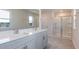Well-lit bathroom featuring a double vanity, a large mirror, and a glass-enclosed shower at 100 Tobacco Woods Dr, Youngsville, NC 27596