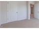 A bedroom with neutral carpeting and a white door with silver hardware is shown at 100 Tobacco Woods Dr, Youngsville, NC 27596