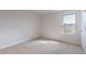 Bright bedroom featuring a large window for natural light and plush neutral carpeting at 100 Tobacco Woods Dr, Youngsville, NC 27596