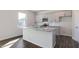 Bright kitchen with gray cabinets, granite countertops, stainless steel appliances, and a center island at 100 Tobacco Woods Dr, Youngsville, NC 27596