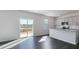 Bright living space with a sliding glass door to a deck, a view to the kitchen, and hardwood floors at 100 Tobacco Woods Dr, Youngsville, NC 27596