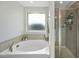 Well-lit bathroom with a soaking tub and a separate glass-enclosed shower at 1003 Frisco Ct, Durham, NC 27703