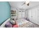 This bedroom features a playful pastel palette, wall-mounted bookshelf, and a white-framed bed at 1003 Frisco Ct, Durham, NC 27703