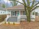 Charming home featuring a inviting front porch, landscaped yard, and mature tree at 1012 Holloway St, Durham, NC 27701