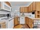 Functional kitchen featuring wood cabinets, white appliances, and a convenient layout at 104 Piquot Drive, Louisburg, NC 27549