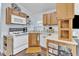 Efficient kitchen featuring white appliances, light wood cabinetry, and wood flooring at 104 Piquot Drive, Louisburg, NC 27549