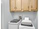 Functional laundry area with modern washer, dryer, and convenient storage cabinets at 104 Piquot Drive, Louisburg, NC 27549