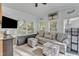 Bright living room with neutral walls, a grey sofa, and many windows with wooded views at 104 Piquot Drive, Louisburg, NC 27549