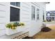 Exterior detail showcases flower boxes with vibrant yellow flowers beneath a window and next to a door, enhancing curb appeal at 106 Cottage Way # 33, Pittsboro, NC 27312