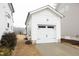 Detached one-car garage with white door that has black accents and a paved driveway complements the home's aesthetic at 106 Cottage Way # 33, Pittsboro, NC 27312