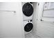 Efficient laundry closet features stacked washer and dryer, with overhead rack on patterned floors at 106 Cottage Way # 33, Pittsboro, NC 27312