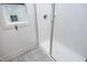 Modern shower featuring white tiles, glass door, and gray and white patterned tile floors at 106 Cottage Way # 33, Pittsboro, NC 27312