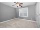 Clean, empty bedroom featuring soft carpet, a ceiling fan, a window with blinds and a closet at 1068 Tender Dr, Apex, NC 27502